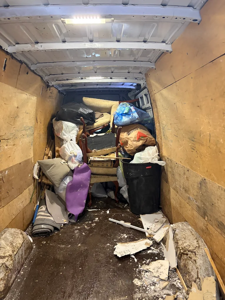 The back of the Sprinter packed full with furniture, bags and household junk from a full cleanout